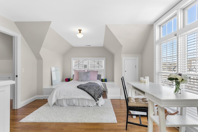 bedroom with lofted ceiling, baseboards, and wood finished floors