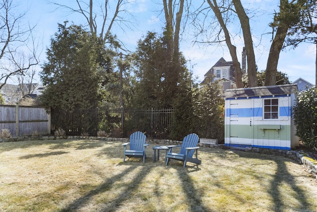 view of yard with an outbuilding, a storage unit, and a fenced backyard