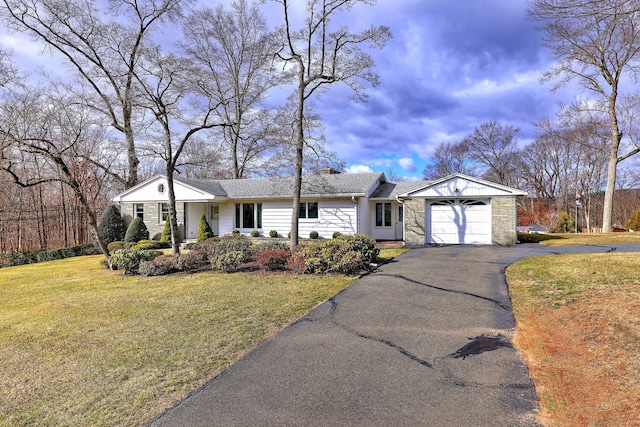 ranch-style house with a front yard, an attached garage, stone siding, and driveway