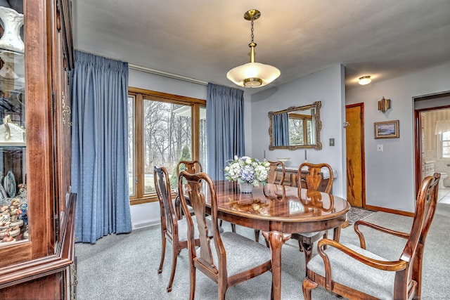 carpeted dining space with baseboards