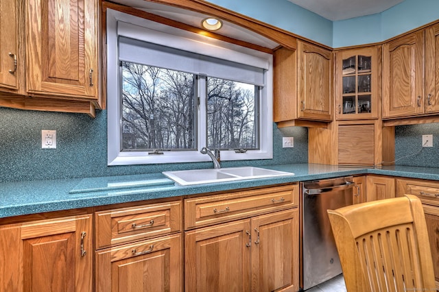 kitchen featuring decorative backsplash, a sink, brown cabinetry, glass insert cabinets, and dishwasher