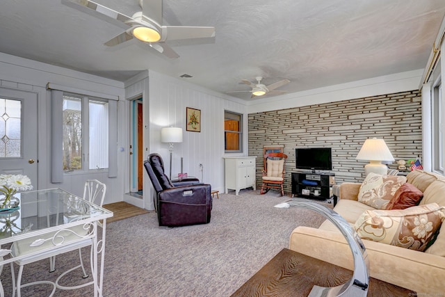 living room with visible vents, carpet flooring, and a ceiling fan