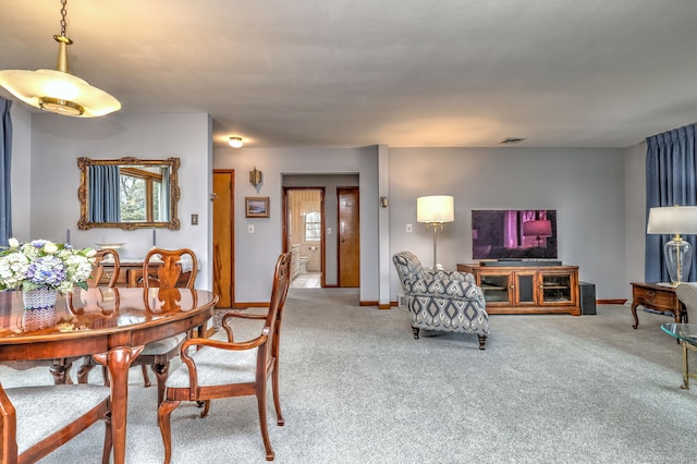 carpeted dining room with visible vents and baseboards