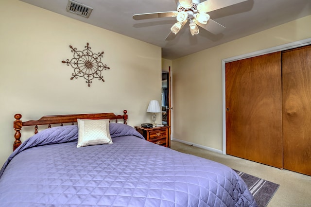 carpeted bedroom featuring a ceiling fan, visible vents, a closet, and baseboards