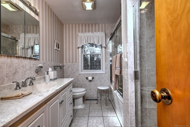 full bath featuring tile patterned floors, toilet, tile walls, wallpapered walls, and vanity