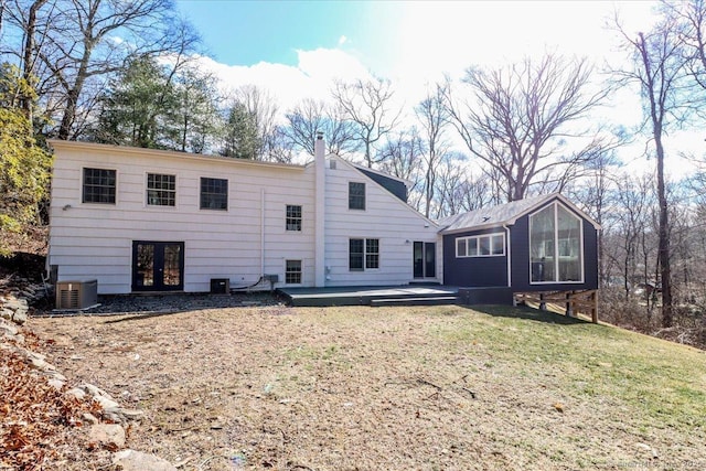 back of property featuring a wooden deck, central AC unit, french doors, a lawn, and a chimney