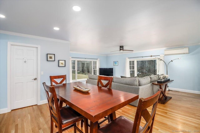 dining area featuring an AC wall unit, ornamental molding, recessed lighting, light wood-style floors, and baseboards