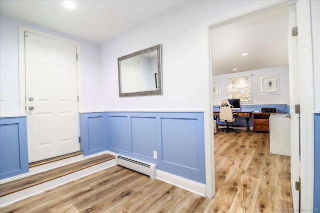 foyer entrance with light wood-style flooring, recessed lighting, wainscoting, and a baseboard radiator