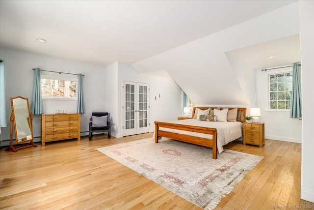 bedroom featuring french doors, multiple windows, lofted ceiling, and wood finished floors