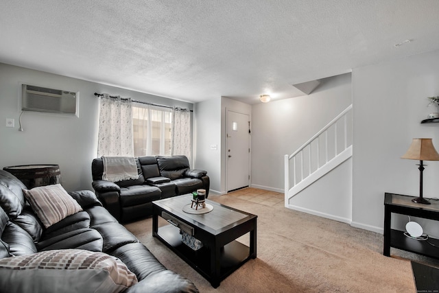 living room with a wall mounted AC, a textured ceiling, stairway, baseboards, and light colored carpet