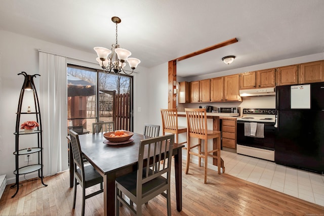 dining space featuring a notable chandelier and light wood-style flooring