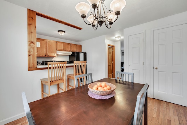 dining space featuring a notable chandelier, light wood-type flooring, and baseboards