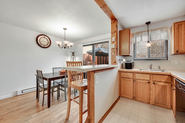 kitchen featuring a sink, decorative light fixtures, black dishwasher, an inviting chandelier, and light countertops