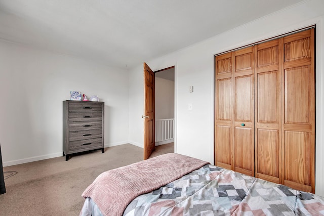 bedroom featuring a closet, baseboards, and light colored carpet