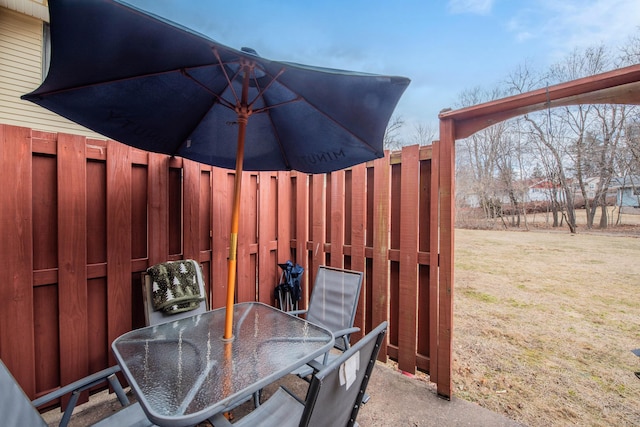 exterior space with outdoor dining area, a yard, and fence