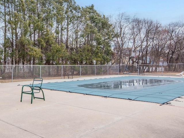 community pool with a patio and fence