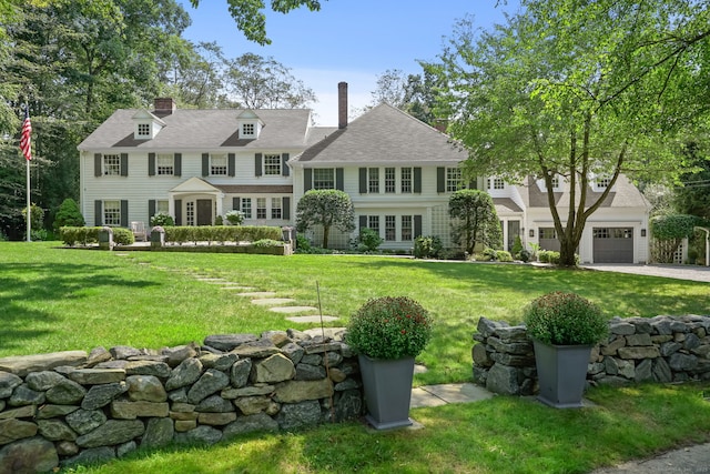 exterior space featuring a garage, roof with shingles, and a front yard