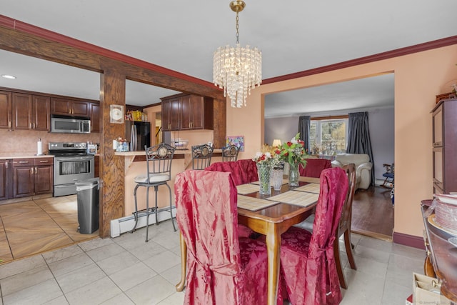 dining space featuring baseboards, ornamental molding, a baseboard radiator, and an inviting chandelier