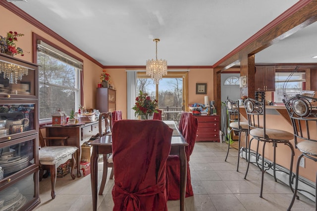 dining space featuring a notable chandelier, a wealth of natural light, and crown molding