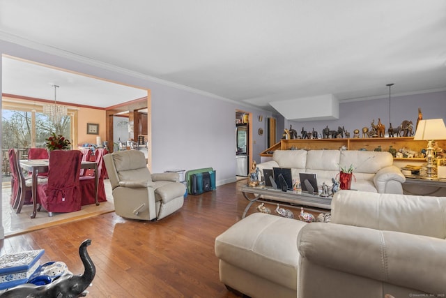 living area with wood-type flooring, a chandelier, and crown molding