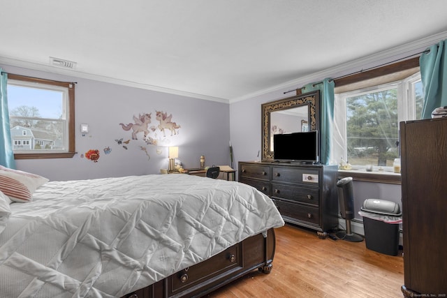 bedroom featuring light wood finished floors, visible vents, multiple windows, and ornamental molding