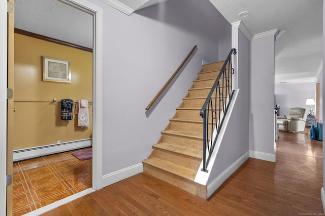 stairs with a baseboard heating unit, crown molding, and wood finished floors