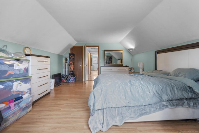 bedroom featuring lofted ceiling and light wood-type flooring