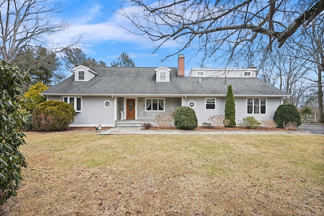 view of front facade featuring a shingled roof, a chimney, and a front lawn