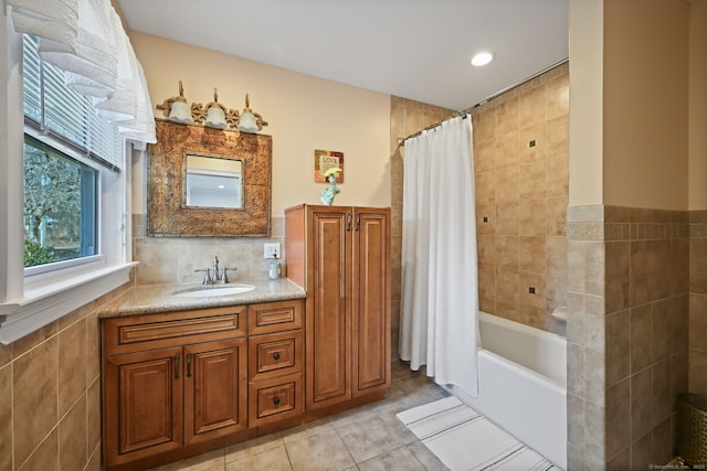 bathroom featuring shower / tub combo, vanity, tile walls, and tile patterned floors