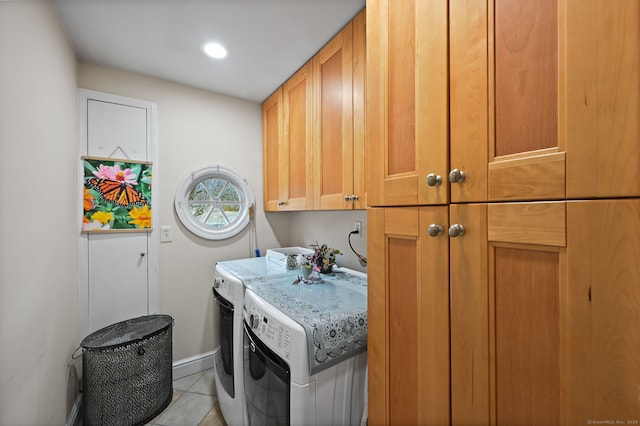 clothes washing area featuring cabinet space, washing machine and dryer, light tile patterned floors, and baseboards