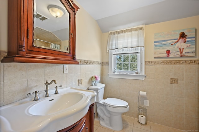 full bath with toilet, vaulted ceiling, vanity, a shower with curtain, and tile patterned floors