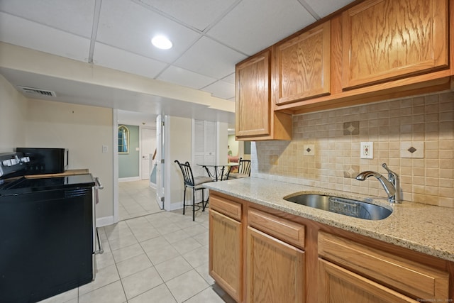 kitchen featuring black electric range, visible vents, a sink, and decorative backsplash