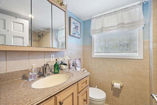 full bathroom featuring tiled shower, tile walls, toilet, and vanity