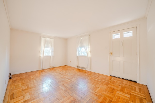 entrance foyer with ornamental molding, visible vents, and baseboards