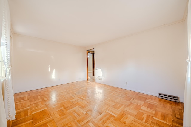 spare room with ornamental molding, visible vents, and baseboards