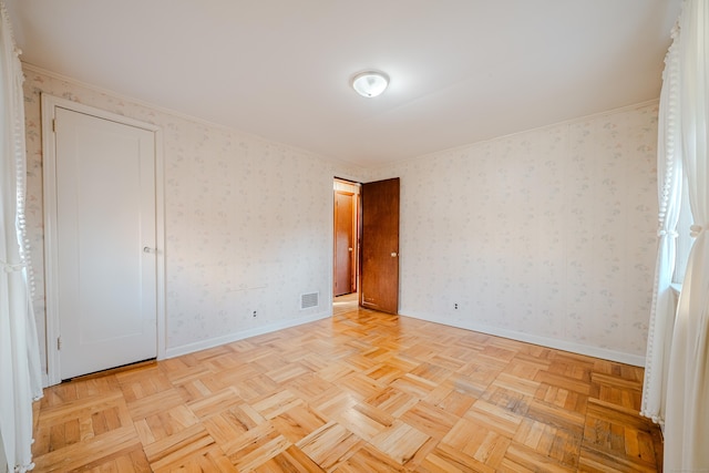 spare room with baseboards, visible vents, and wallpapered walls