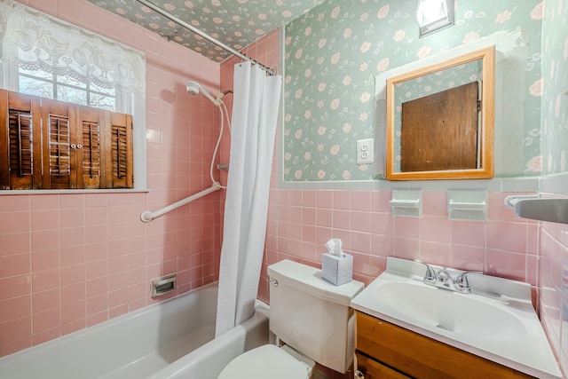 bathroom featuring a wainscoted wall, tile walls, shower / bathtub combination with curtain, toilet, and wallpapered walls