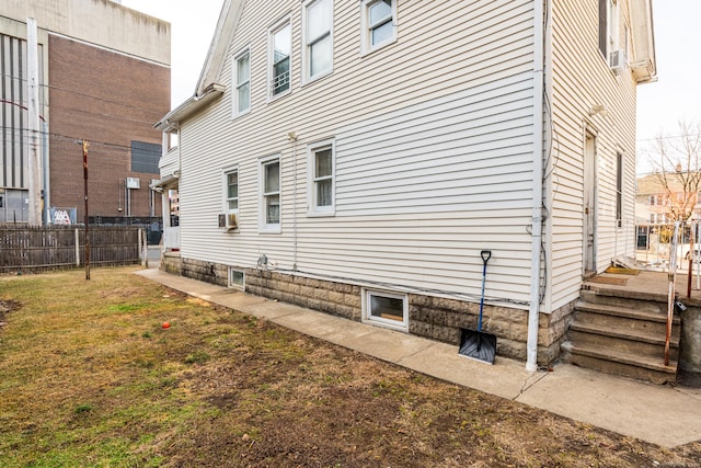 view of side of property with a yard, cooling unit, and fence