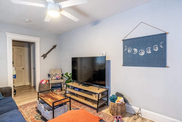 living room featuring ceiling fan, wood finished floors, and baseboards