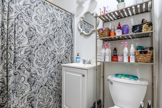 bathroom featuring toilet, vanity, and a shower with curtain