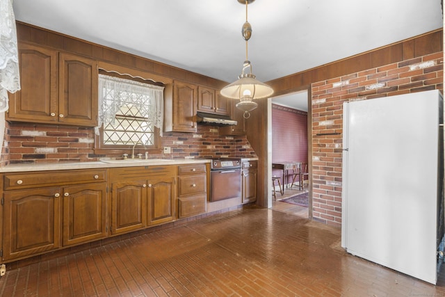 kitchen featuring light countertops, freestanding refrigerator, a sink, oven, and under cabinet range hood