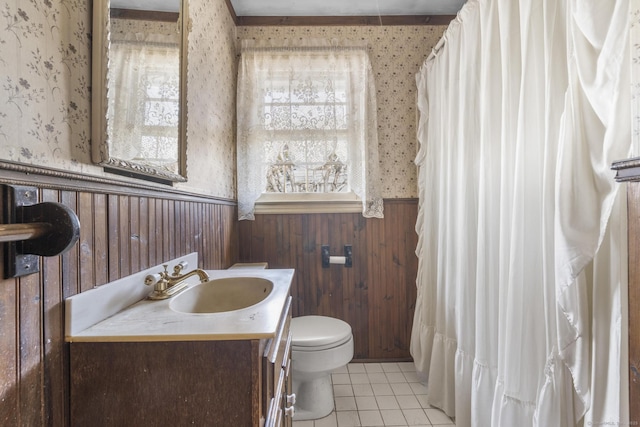 full bathroom with toilet, vanity, wainscoting, tile patterned floors, and wallpapered walls