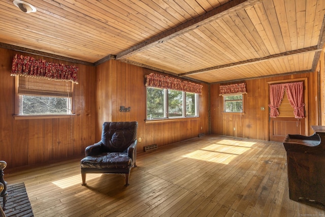 living area with wood ceiling, wood-type flooring, wooden walls, and beam ceiling