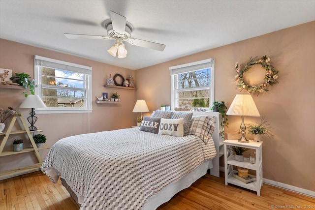 bedroom featuring a ceiling fan, baseboards, and hardwood / wood-style floors