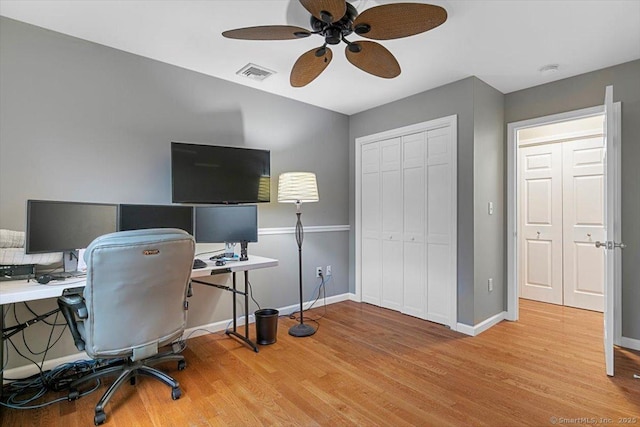 home office featuring wood finished floors, visible vents, and baseboards