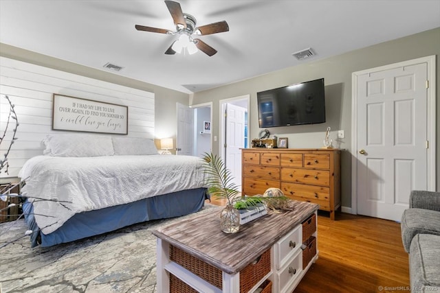 bedroom with wood finished floors, visible vents, and a ceiling fan