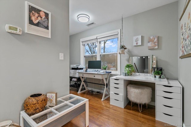 office space with wood finished floors and visible vents