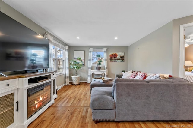 living room with recessed lighting, light wood-style flooring, and baseboards