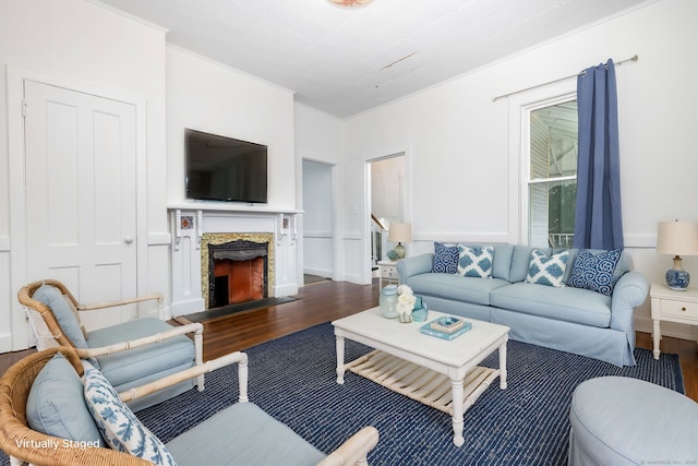 living room with dark wood-style floors, a fireplace, and ornamental molding