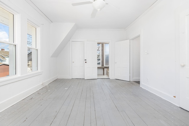 bonus room with hardwood / wood-style floors, a ceiling fan, and baseboards